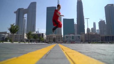 Yavaş çekimde Dubai 'nin arka planında ip atlayan genç bir kız.