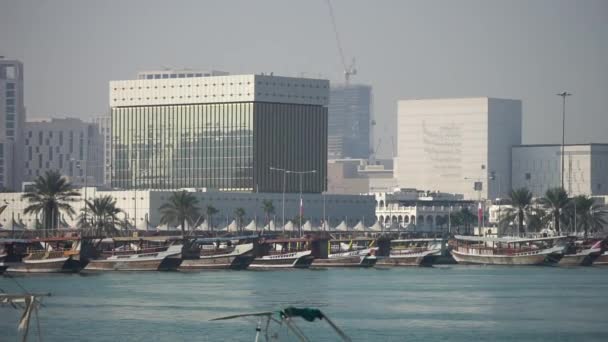卡塔尔多哈，2020年1月。Ras Al Nasa渔港附近的传统渔船停泊在平静蓝水的长泊位上 — 图库视频影像