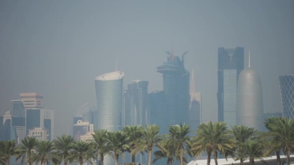 Доха, Катар, январь 2020 года. Панорамный вид на современный небосклон Мбаппе с пальмами на переднем плане. Концепция здоровой окружающей среды — стоковое видео