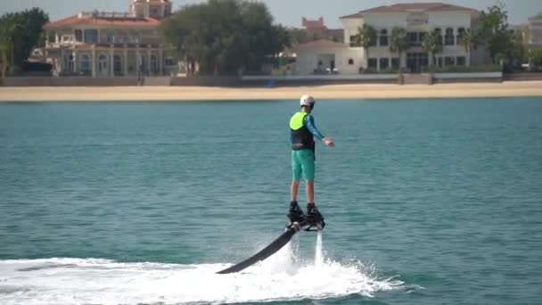 El principiante está aprendiendo a manejar en el flyboard acuático. Descanso extremo en el mar — Vídeo de stock