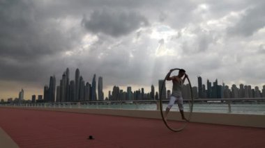 Günbatımında Dubai 'nin şehir planına sahip Cyr Wheel sanatçısı