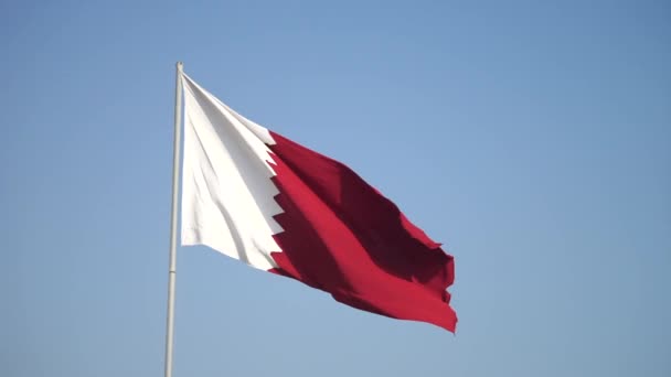 Элегантный флаг Катара, развевающийся в небе в яркий солнечный день в замедленной съемке — стоковое видео