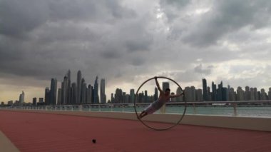 Günbatımında Dubai 'nin şehir planına sahip Cyr Wheel sanatçısı