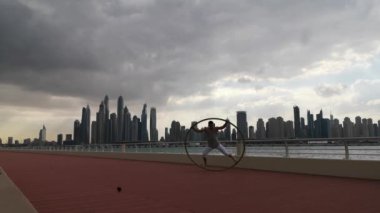 Günbatımında Dubai 'nin şehir planına sahip Cyr Wheel sanatçısı