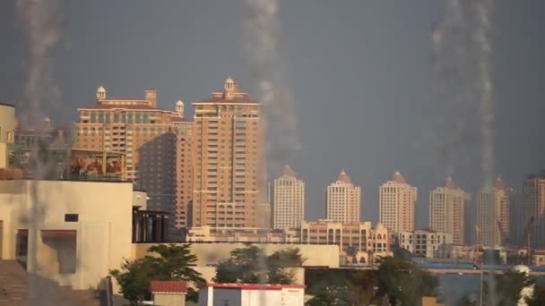 Vista borrosa de una ciudad con fuentes de agua en cámara lenta en primer plano. Tomado en un día soleado, Doha, Qatar — Vídeo de stock