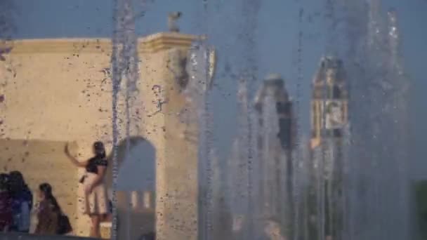 Vista borrosa de una ciudad con fuentes de agua en cámara lenta en primer plano. Tomado en un día soleado, Doha, Qatar — Vídeos de Stock