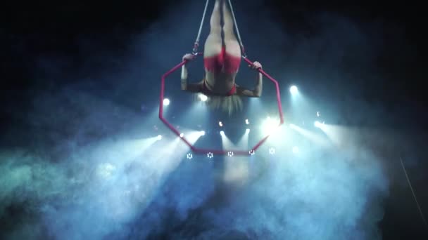 Sottile e sexy acrobata femminile aerea sul palco con cerchio aereo con luci spot sullo sfondo — Video Stock