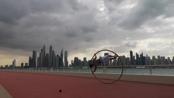 Cyr Wheel artista con fondo de paisaje urbano de Dubai durante la puesta del sol — Vídeo de stock