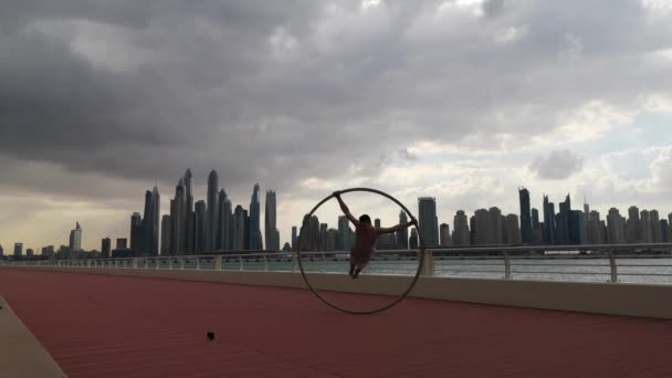 Cyr Roue artiste avec fond de paysage urbain de Dubaï pendant le coucher du soleil — Video