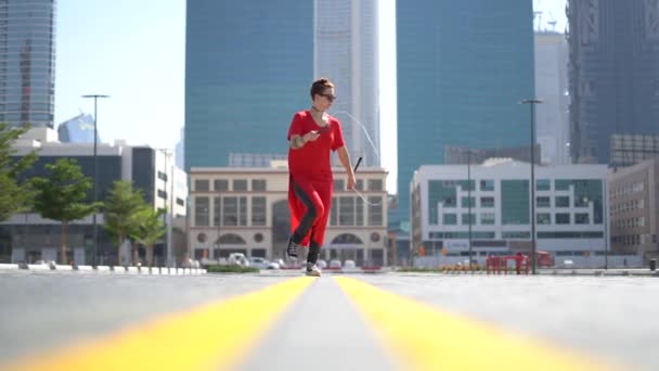 Chica joven saltando con cuerda de salto con fondo de paisaje urbano de Dubai en cámara lenta — Vídeos de Stock