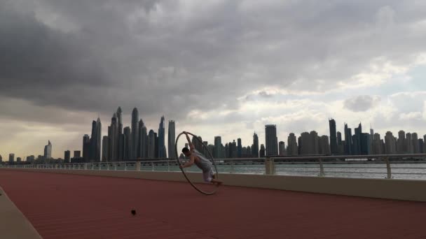 Günbatımında Dubai 'nin şehir planına sahip Cyr Wheel sanatçısı — Stok video