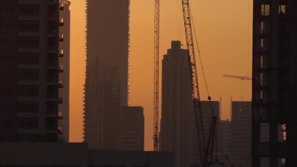 Turmdrehkräne auf der Baustelle und Hintergrund der Stadt bei Sonnenuntergang — Stockvideo