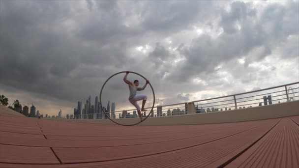 Cyr Wheel kunstenaar met stadsgezicht achtergrond van Dubai tijdens zonsondergang — Stockvideo