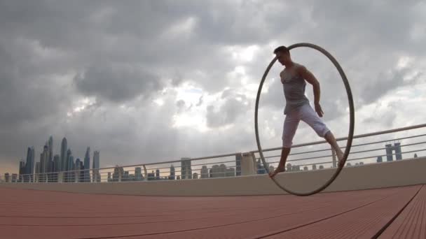 Cyr Wheel artysta z tłem miasta Dubaju podczas zachodu słońca — Wideo stockowe