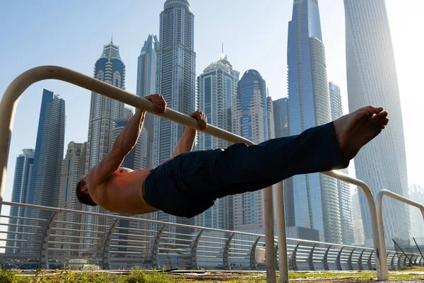 Μυώδης άνθρωπος κάνει προπόνηση στο δρόμο με το αστικό τοπίο των ουρανοξυστών στο παρασκήνιο στο Ντουμπάι. Έννοια του υγιεινού τρόπου ζωής και σύγχρονο — Φωτογραφία Αρχείου