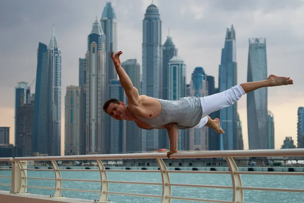 Uomo muscolare che fa allenamento per strada con paesaggio urbano di grattacieli sullo sfondo a Dubai. Concetto di stile di vita sano e moderno — Foto Stock