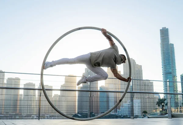 Cyr Wheel καλλιτέχνης με φόντο αστικό τοπίο του Ντουμπάι κατά τη διάρκεια του ηλιοβασιλέματος — Φωτογραφία Αρχείου