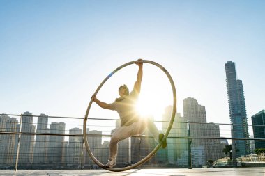 Günbatımında Dubai 'nin şehir planına sahip Cyr Wheel sanatçısı