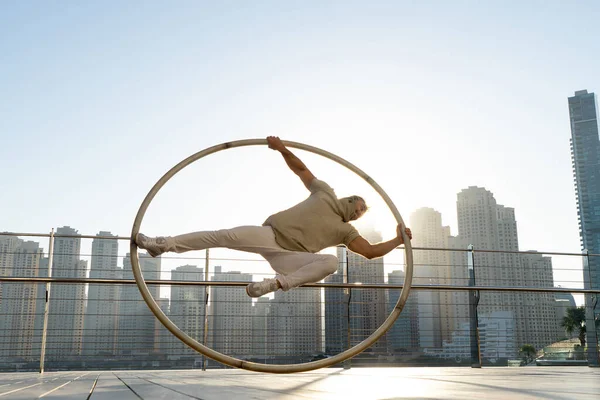 Cyr Wheel artist med stadsbild bakgrund i Dubai under solnedgången — Stockfoto