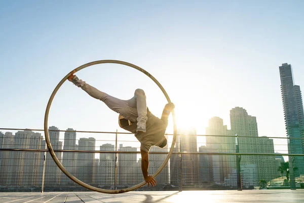 Cyr Wheel artista con fondo de paisaje urbano de Dubai durante la puesta del sol — Foto de Stock