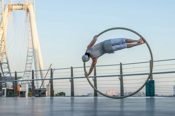 Ντουμπάι, Φεβρουάριος 2020. Cyr Wheel καλλιτέχνης με τροχό Ferris στο παρασκήνιο του Ντουμπάι κατά τη διάρκεια του ηλιοβασιλέματος — Φωτογραφία Αρχείου