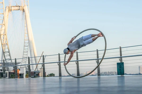 Dubai, Februar 2020. Cyr Wheel Artist mit Riesenrad auf dem Hintergrund von Dubai bei Sonnenuntergang — Stockfoto