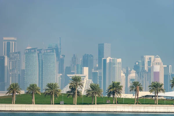 Vista panorámica del horizonte moderno de Doha con palmeras en primer plano. Concepto de medio ambiente saludable —  Fotos de Stock