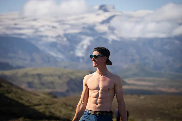 Hombre caucásico musculoso alto con torso desnudo de pie sobre la montaña y el fondo del cielo. Promover un estilo de vida activo, deportivo y saludable —  Fotos de Stock