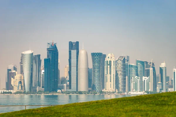 Vista panorámica del horizonte moderno de Doha con césped verde en primer plano. Concepto de medio ambiente saludable — Foto de Stock
