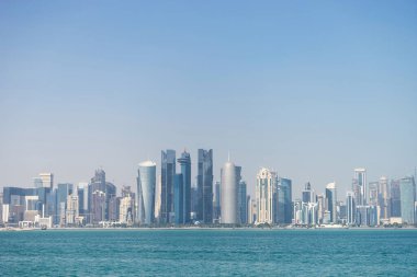 Doha 'nın mavi sulardaki modern ufuk çizgisinin panoramik görüntüsü. Zenginlik ve lüks kavramı