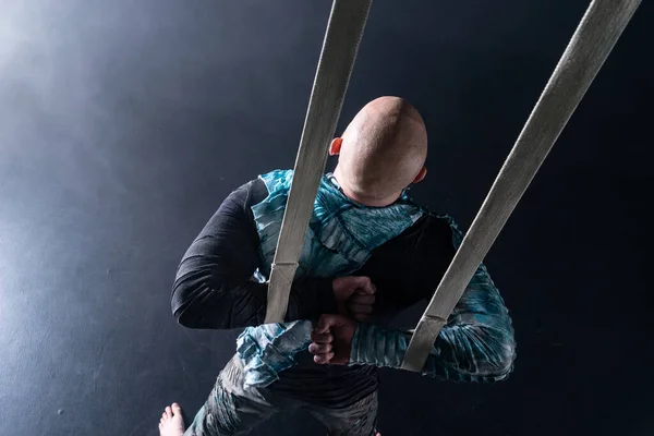 Circus artist on the aerial straps with costume on the black and smoked background. Concept of suffering, despair and defeat — 스톡 사진