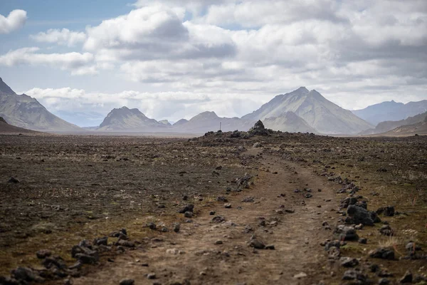 Логавегур мандрує походом, панорамним видом на гору з вулканічним ландшафтом під час шторму попелу. Ісландія — стокове фото