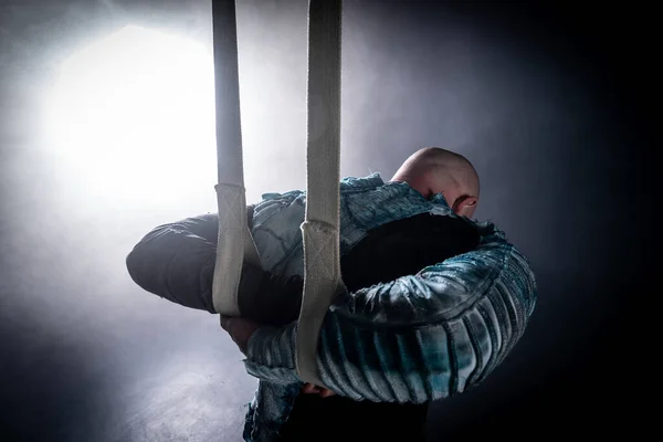 Circus artist on the aerial straps with costume on the black and smoked background. Concept of suffering, despair and defeat — 스톡 사진