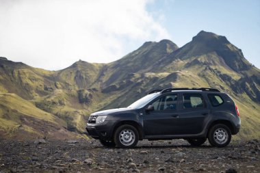 4x4 araç İzlanda 'nın Landmannalaugar bölgesine giden siyah lav tarlasında park halinde.