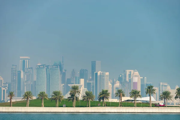 Blick auf die moderne Skyline von Doha mit Palmen im Vordergrund. Konzept einer gesunden Umwelt — Stockfoto