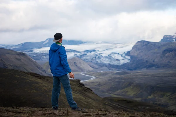 Parte trasera de un hombre caucásico alto que llevaba una chaqueta de pie sobre una montaña nevada en la pista de Laugavegur, Islandia. Promover un estilo de vida saludable — Foto de Stock