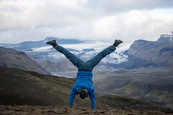 Joven de pie en sus manos con la montaña nevada y fondo glaciar en el camino del sendero Laugavegur, Islandia. Promover la actividad y el estilo de vida saludable — Foto de Stock