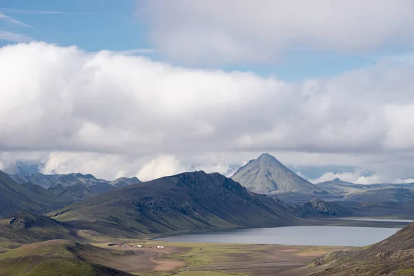 Widok na dolinę górską z zielonymi wzgórzami, strumień rzeczny i jezioro. Ścieżka turystyczna Laugavegur, Islandia — Zdjęcie stockowe