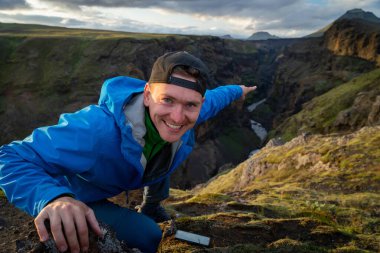 İzlanda, Laugavegur yolu üzerindeki dağ ve kanyon arka planında duran beyaz bir genç. Sağlıklı yaşam tarzını teşvik etmek