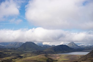 Yeşil tepeleri, nehir deresi ve gölü olan dağ vadisini görün. Laugavegur yürüyüş yolu, İzlanda