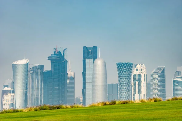 Panoramic view of modern skyline of Doha with green grass foreground. Concept of healthy environment — Stock Photo, Image