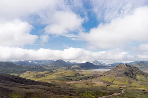 Widok na dolinę górską z zielonymi wzgórzami, strumień rzeczny i jezioro. Ścieżka turystyczna Laugavegur, Islandia — Zdjęcie stockowe