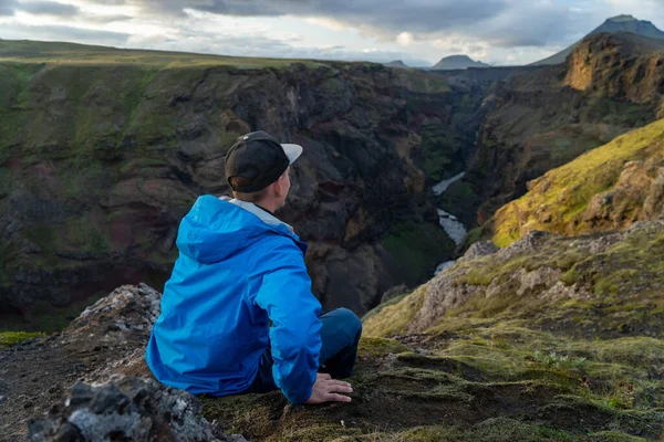 アイスランドのローベグル・トレイルの途中で山と渓谷の背景に立っている白人の若い男。健康的なライフスタイルの推進 — ストック写真