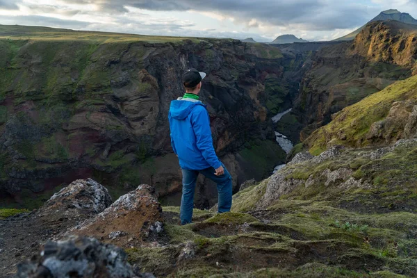 Кавказький хлопець, що стоїть над горою і каньйоном на шляху Лаугавегур, Ісландія. Сприяти здоровому способу життя — стокове фото