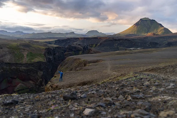 Chico joven caucásico de pie sobre fondo de montaña y cañón en el camino del sendero Laugavegur, Islandia. Promover un estilo de vida saludable — Foto de Stock
