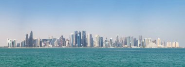 Doha 'nın mavi sulardaki modern ufuk çizgisinin panoramik görüntüsü. Zenginlik ve lüks kavramı