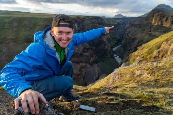 アイスランドのローベグル・トレイルの途中で山と渓谷の背景に立っている白人の若い男。健康的なライフスタイルの推進 — ストック写真