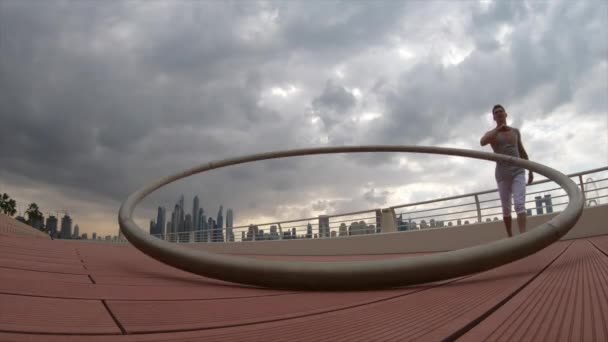 Cyr Wheel καλλιτέχνης με φόντο αστικό τοπίο του Ντουμπάι κατά τη διάρκεια του ηλιοβασιλέματος — Αρχείο Βίντεο