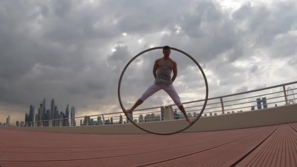 Cyr Wheel artista con fondo de paisaje urbano de Dubai durante la puesta del sol — Vídeo de stock