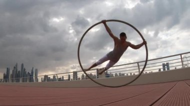 Günbatımında Dubai 'nin şehir planına sahip Cyr Wheel sanatçısı